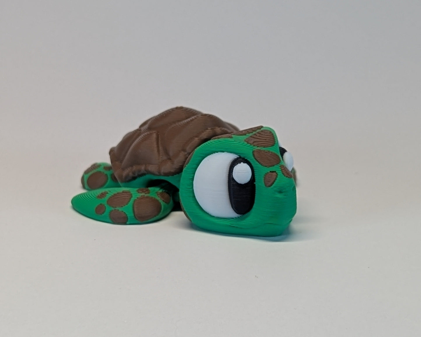 Toy turtle with a brown shell on a light gray background