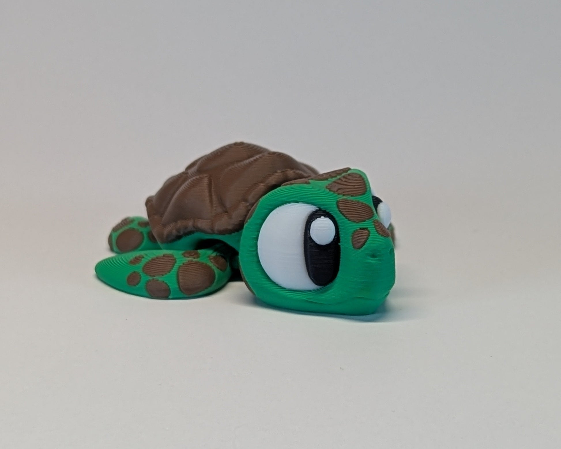 Toy turtle with a brown shell on a light gray background