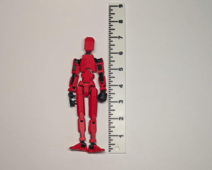 Red toy figure next to a ruler on a light gray background
