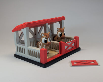 Tiny Habitat Stable with two horse figures on a gray background