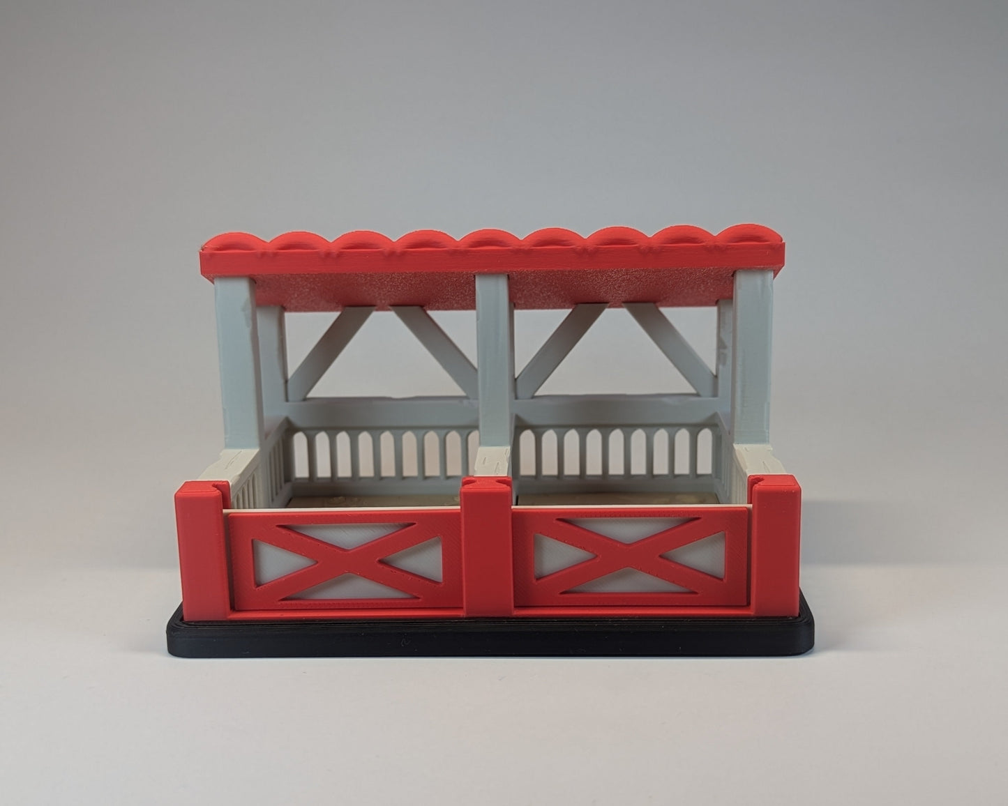 Tiny Habitat Stable with red roof and gate on a gray background